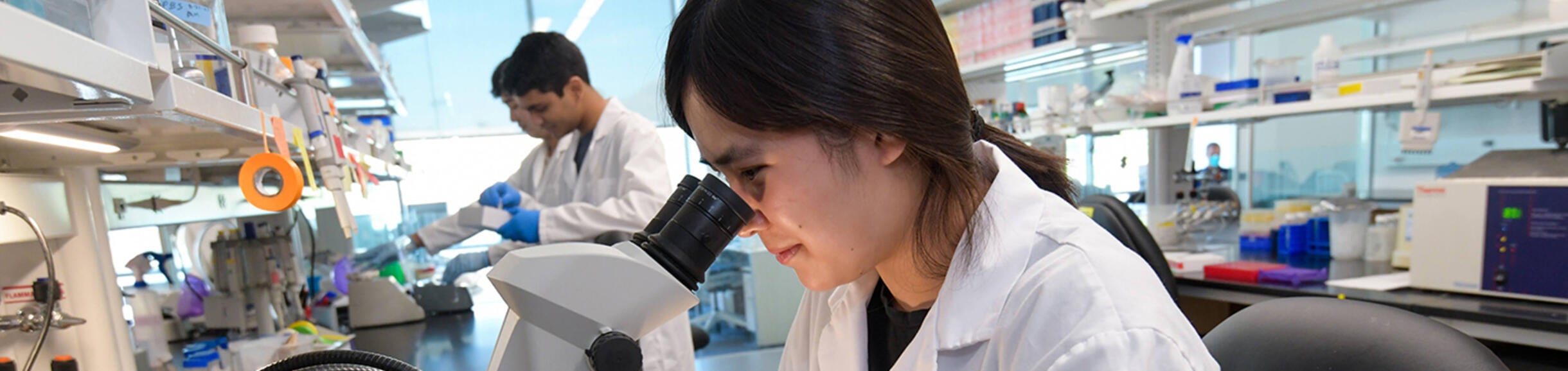 student looking in microscope