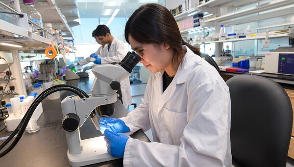 student looking in microscope